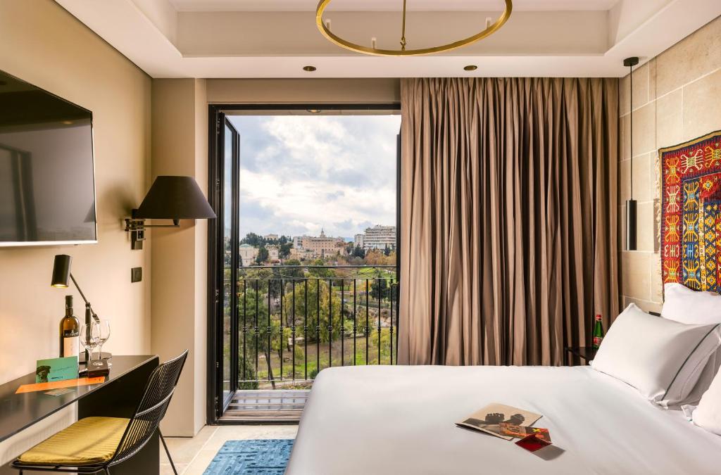 a hotel room with a bed and a large window at Brown JLM Mamilla, a member of Brown Hotels in Jerusalem