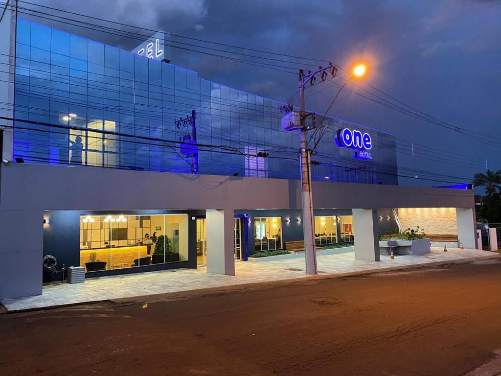 un edificio con una señal azul en el costado. en ONE HOTEL, en Ituiutaba