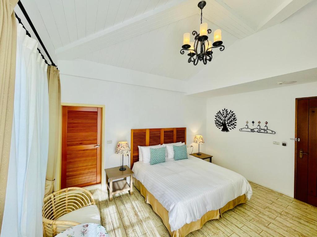 a bedroom with a bed and a chandelier at SpoonDrift Hostal Kenting in Nanwan