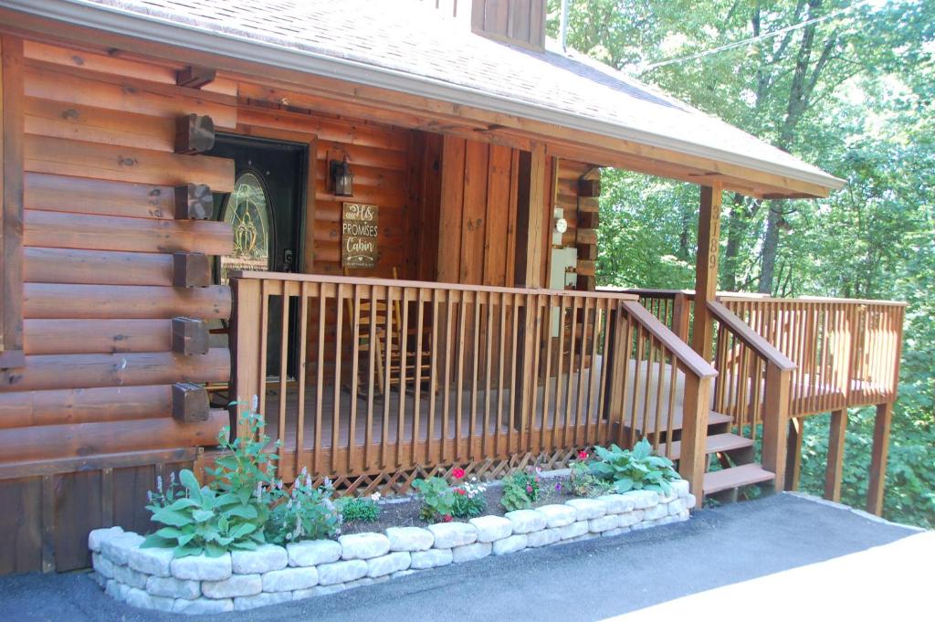 a cabin with a staircase and flowers in front of it at His Promises Cabin in Pigeon Forge