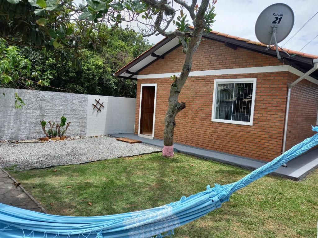 una casa con una hamaca azul delante de ella en Casa em Florianópolis, rio vermelho de 2 quartos bem localizada, en Florianópolis