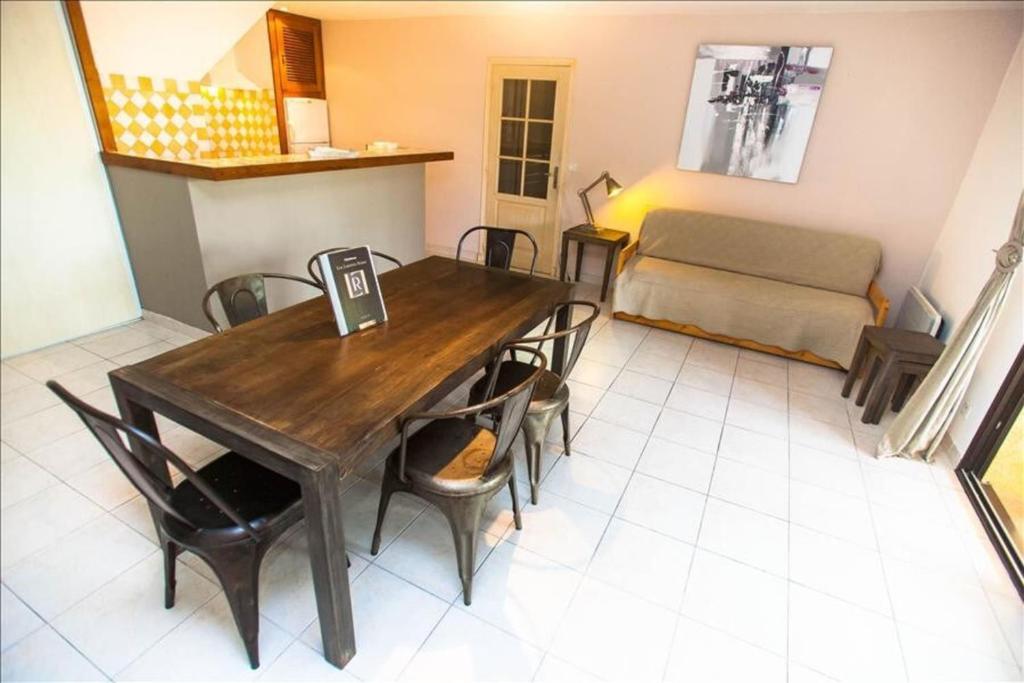 een eetkamer met een tafel en stoelen en een bank bij location de vacances figuier avec jardin barbecue piscine chauffée à Calvi in Calvi