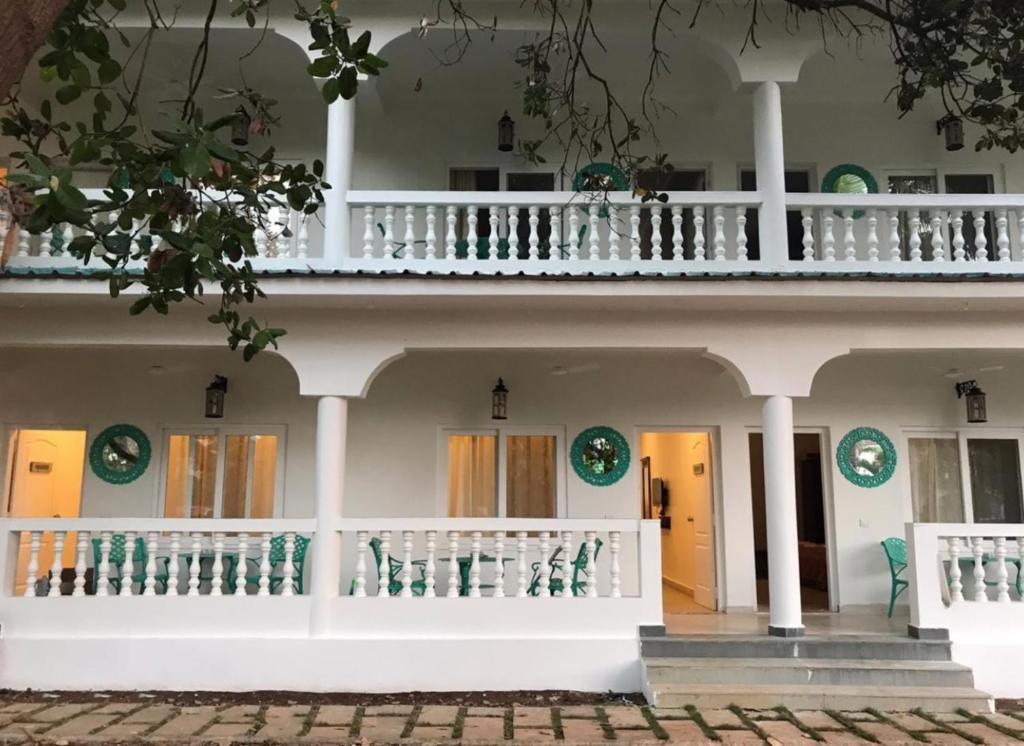 a large white building with a balcony at BaywoodGoa in Morjim