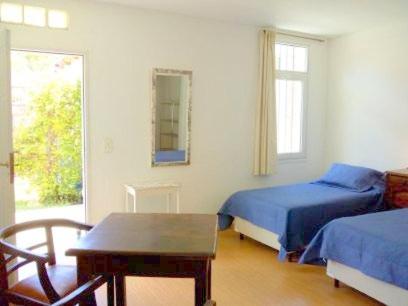 1 dormitorio con 2 camas, mesa y ventana en B&B Garden Atelier en La Cumbre