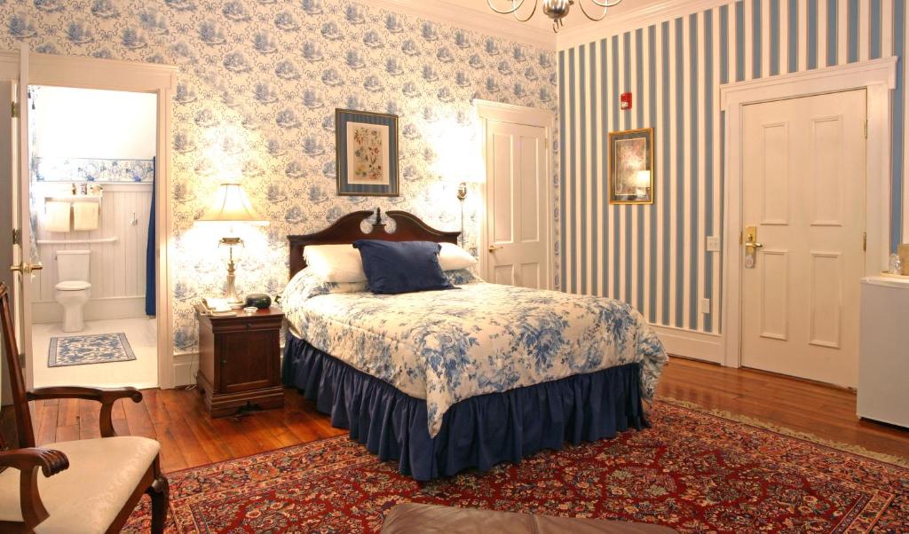Bird-in-Hand Village Inn & Suites في بيرد إن هاند: غرفة نوم بسرير وورق جدران ازرق وابيض