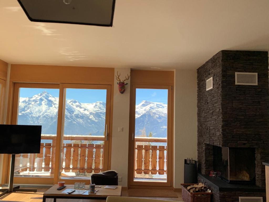 sala de estar con vistas a las montañas nevadas en Ski-In, Ski-Out 4, Veysonnaz en Veysonnaz