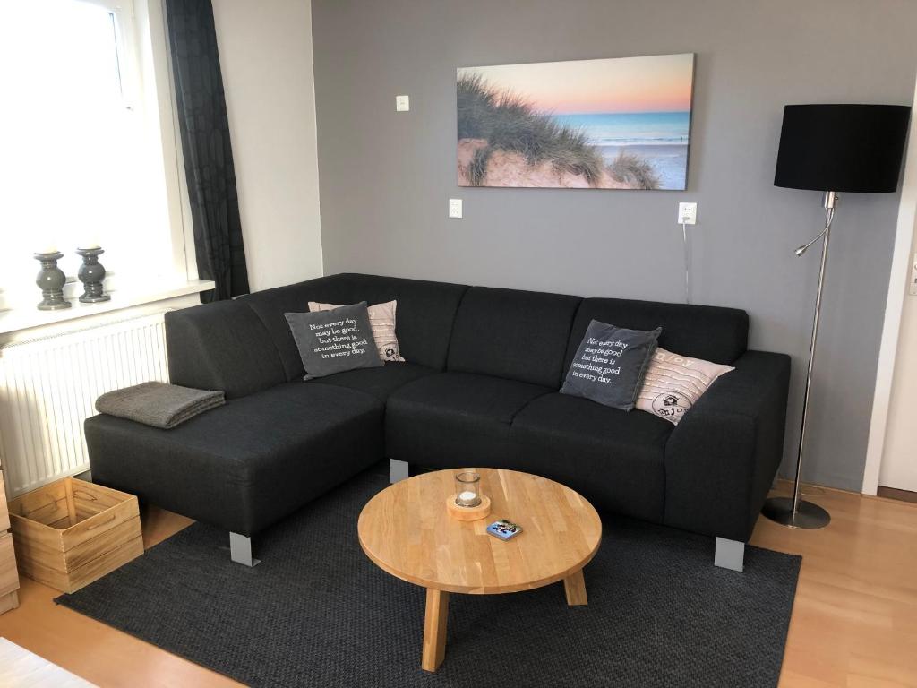 a living room with a black couch and a table at Duinoord Domburg in Domburg