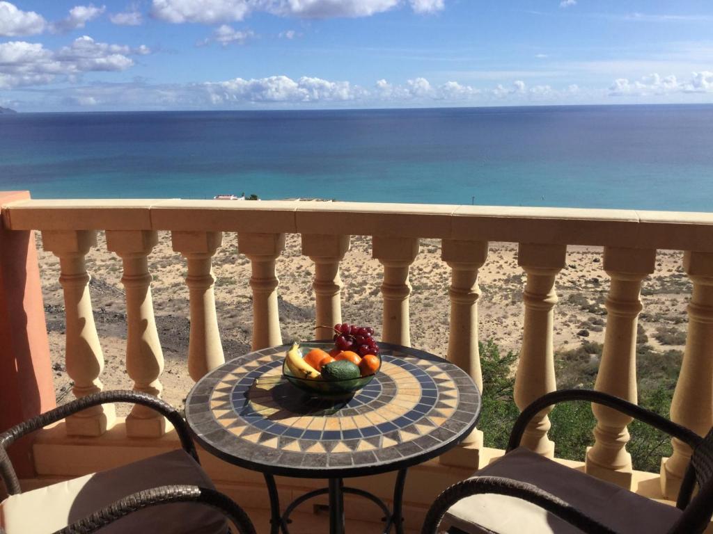 a bowl of fruit on a table on a balcony with the ocean at Casa Sofia in Costa Calma