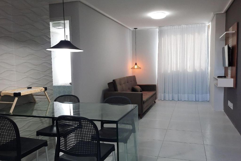 - un salon avec une table en verre et un canapé dans l'établissement Ed. Manoel Cordeiro - Stúdio Meu aconchego II, à Caruaru