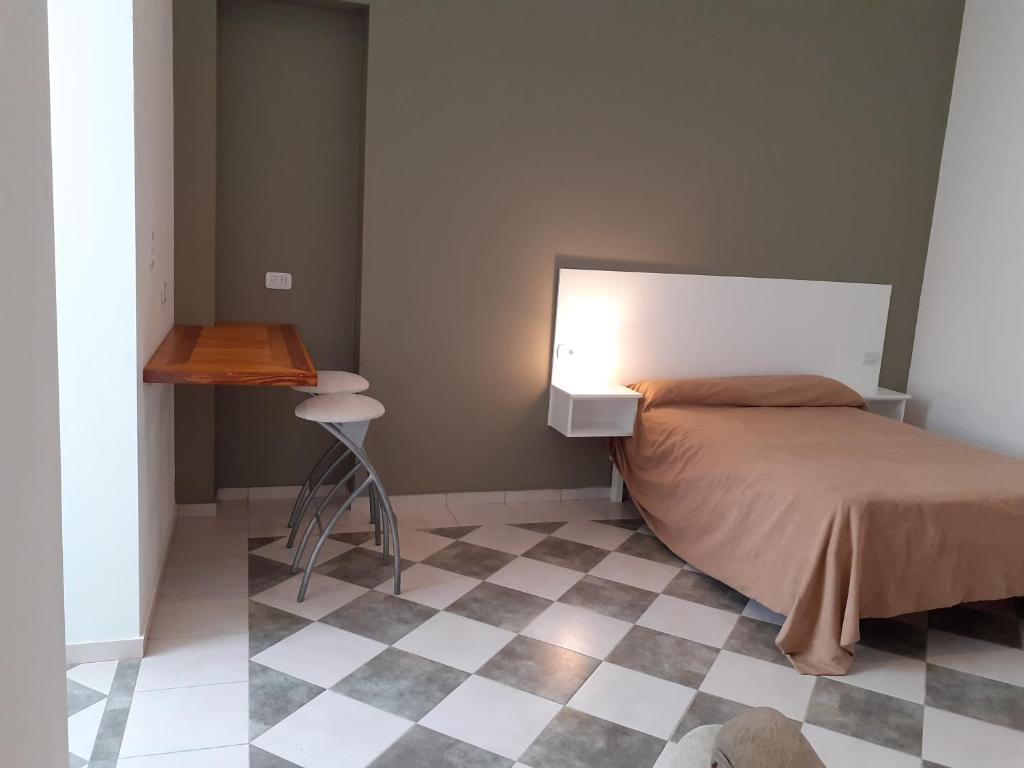 una camera da letto con un letto con una lampada e un pavimento a scacchi di Bello Jazmin 2 a San Rafael