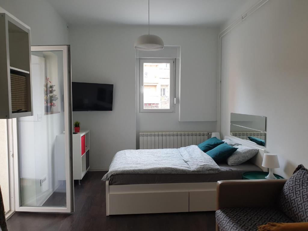 1 dormitorio con cama con almohadas azules y espejo en Studio Apartment "Savski Trg", en Belgrado