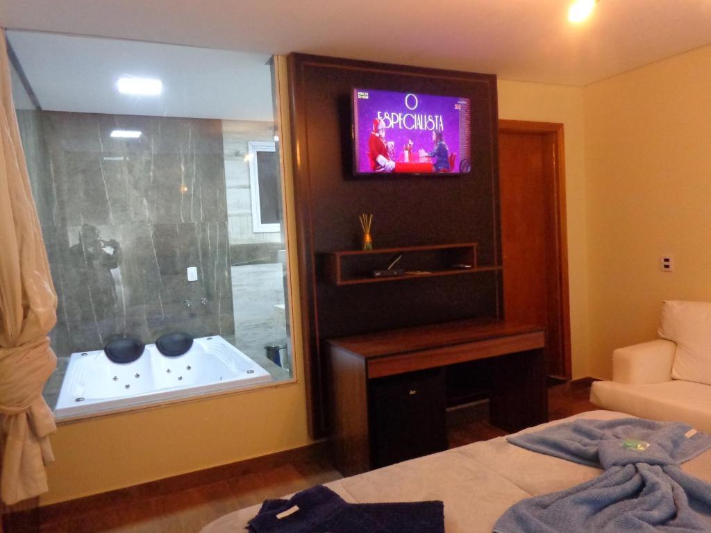 Televízia a/alebo spoločenská miestnosť v ubytovaní Monte Verde Inn Suítes com Hidromassagem dupla