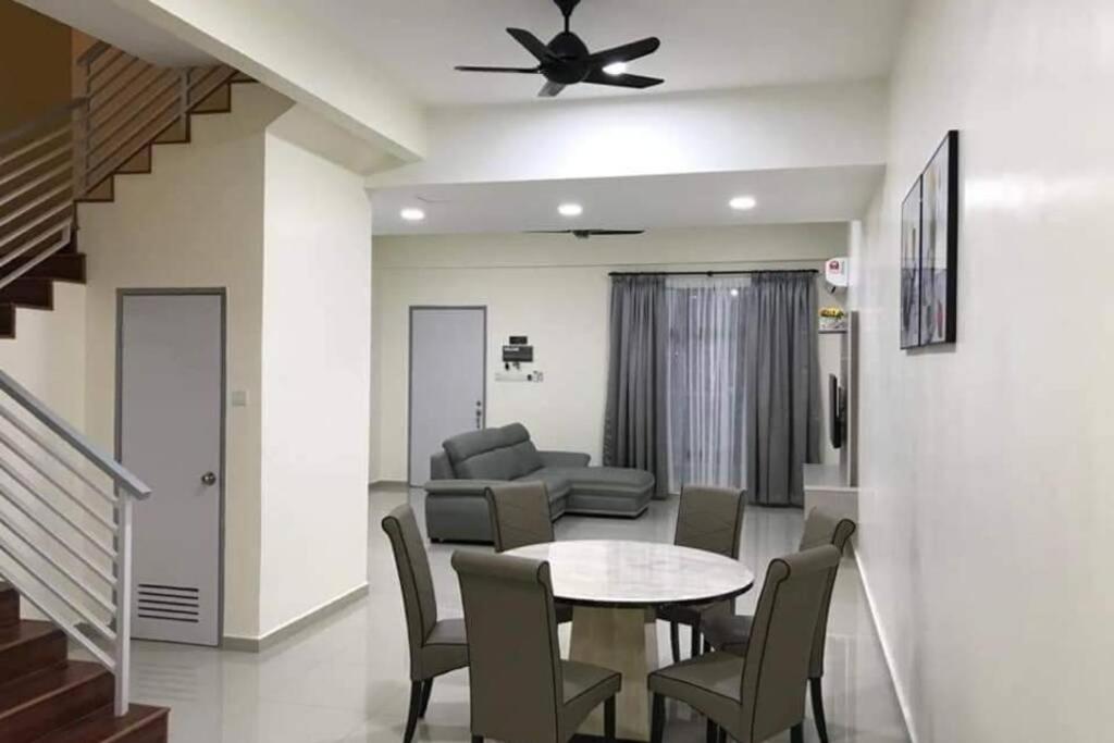 een woonkamer met een tafel en stoelen en een bank bij KS 80 Homestay (15pax)4R3B ~WiFi~ near Jetty in Kuala Selangor