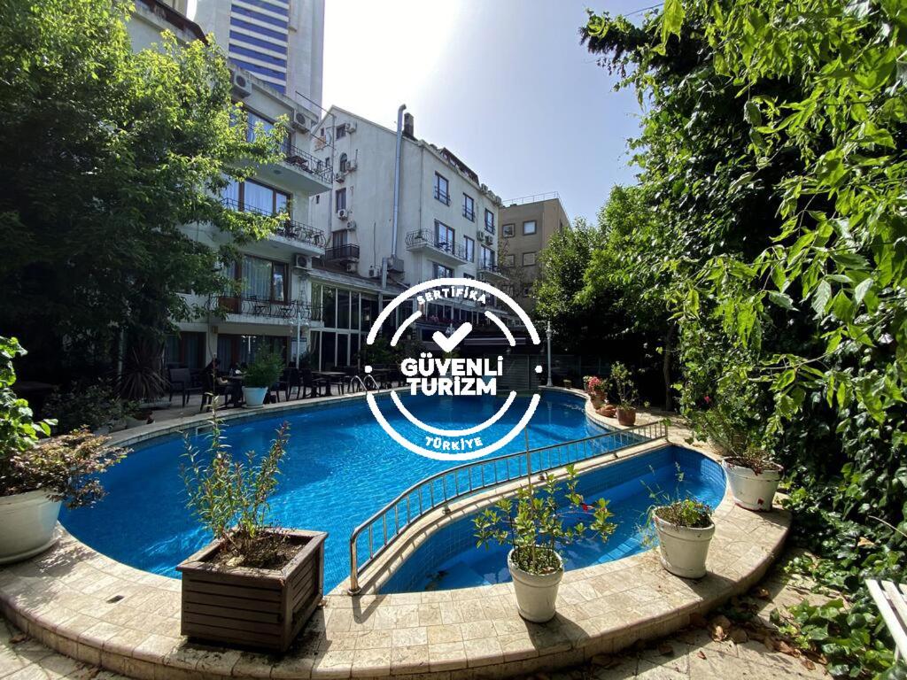 a swimming pool with a sign in front of a building at Villa Blanche Hotel SPA & Garden Pool in Istanbul