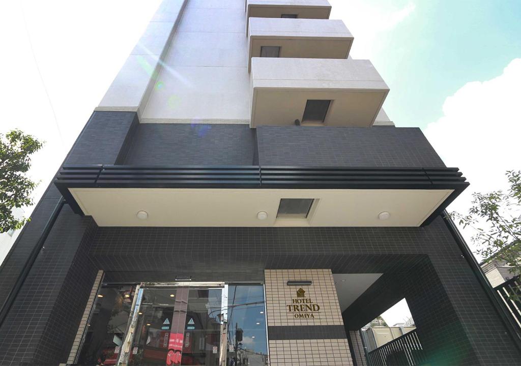 a tall building with a black and white facade at Hotel Trend Omiya in Saitama