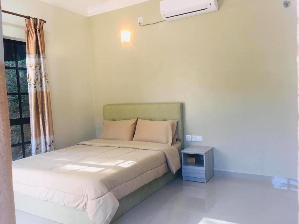 a small bedroom with a bed and a night stand at Lang Buana Eco Park in Jerantut