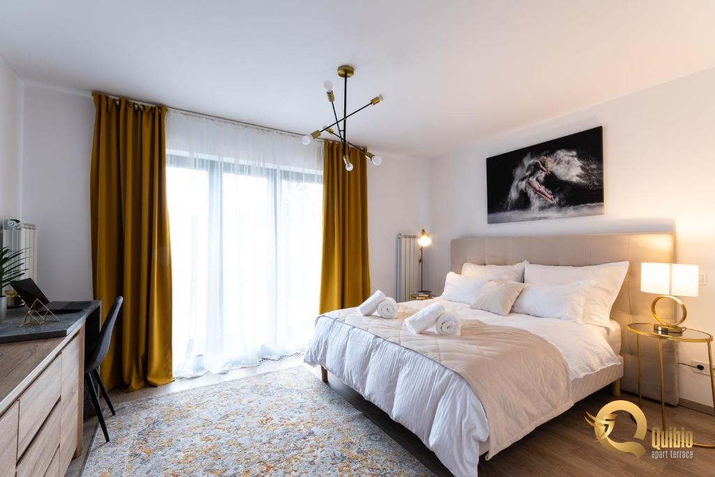 a bedroom with a large bed with yellow curtains at Quibio Apart Terrace in Braşov