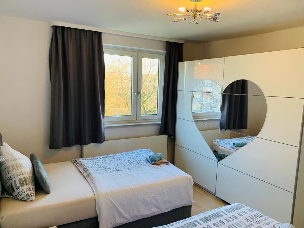 a bedroom with two beds and a mirror at List-vahrenwalder in Hannover