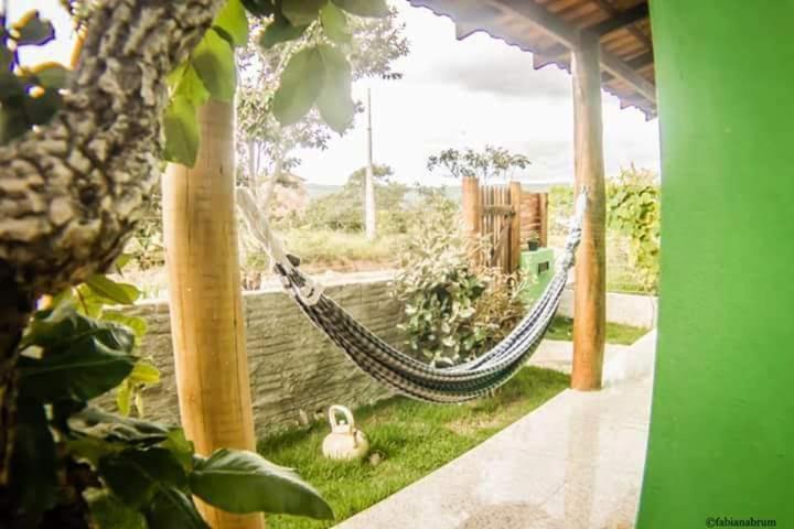 a hammock in a garden with a duck on the grass at Chalé Nova Aurora in Alto Paraíso de Goiás