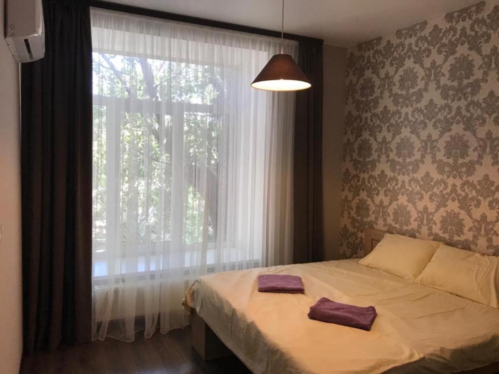 a bedroom with a bed and a large window at #8 Apartments in Odesa