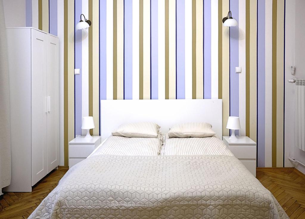 ザコパネにあるApartament Kościuszkiのベッドルーム1室(ストライプの壁の大型ベッド1台付)