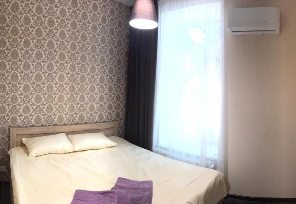 Un dormitorio con una cama blanca y una ventana. en #8 Apartments, en Odessa