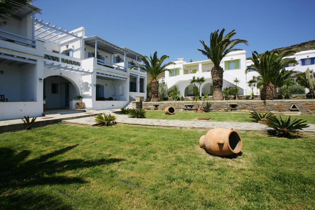 a large white house with palm trees in the yard at Porto Raphael Residences & Suites in Agios Ioannis
