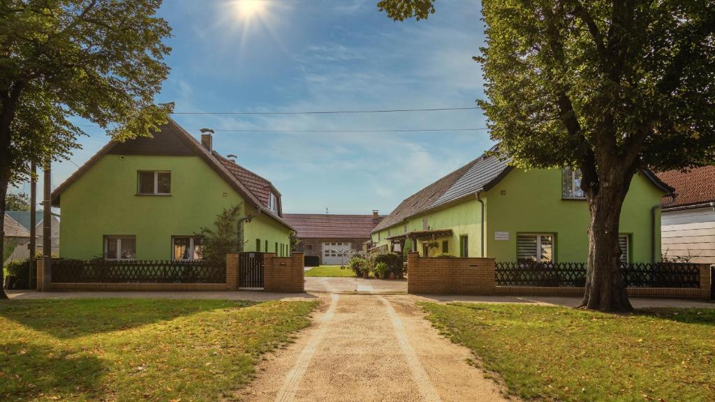 a green house with a tree and a dirt road at Ferienhaus Golm, 04924 Zobersdorf in Bad Liebenwerda