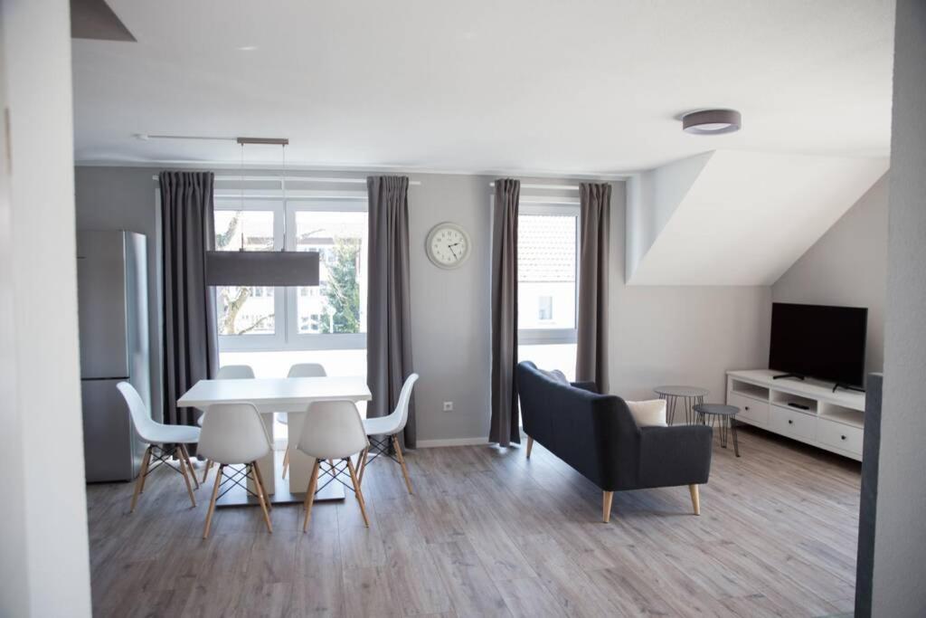 een woonkamer met een eettafel en stoelen bij moderne Neubau-Wohnung mit Kamin und 35qm Dachterrasse in Trossingen