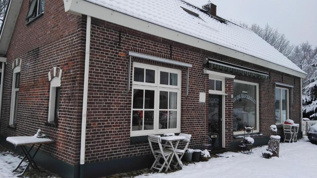 ein rotes Backsteinhaus mit Schnee an den Fenstern in der Unterkunft B&B In De Backerije 2 in Zuidwolde