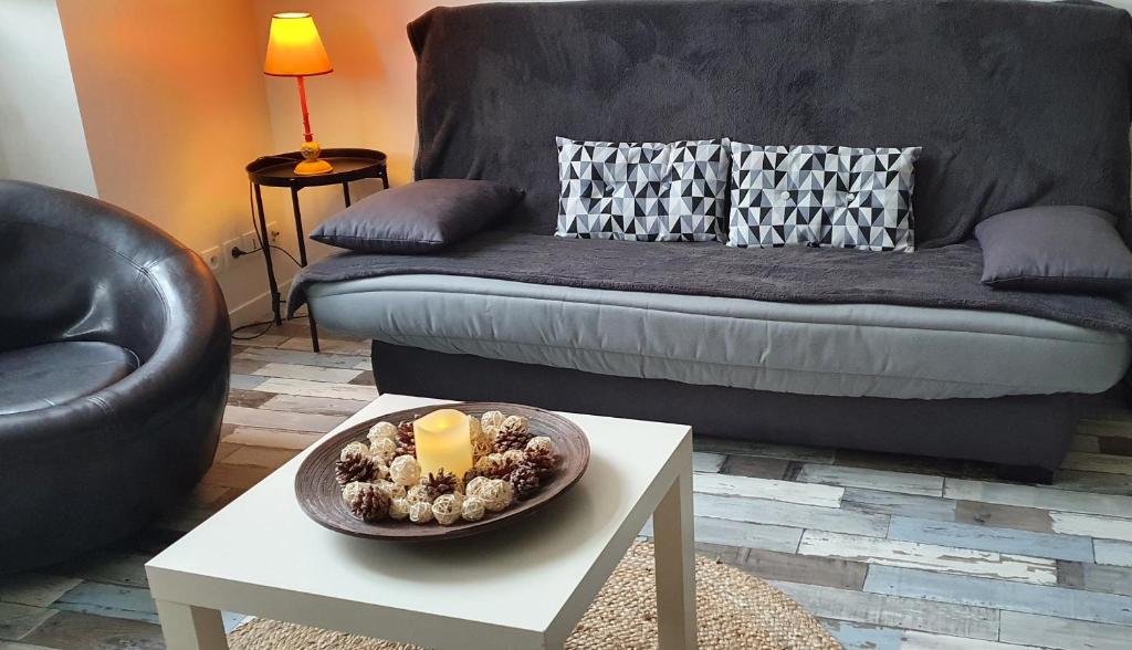 un soggiorno con divano e tavolo con candela di Escale dinannaise a Dinan