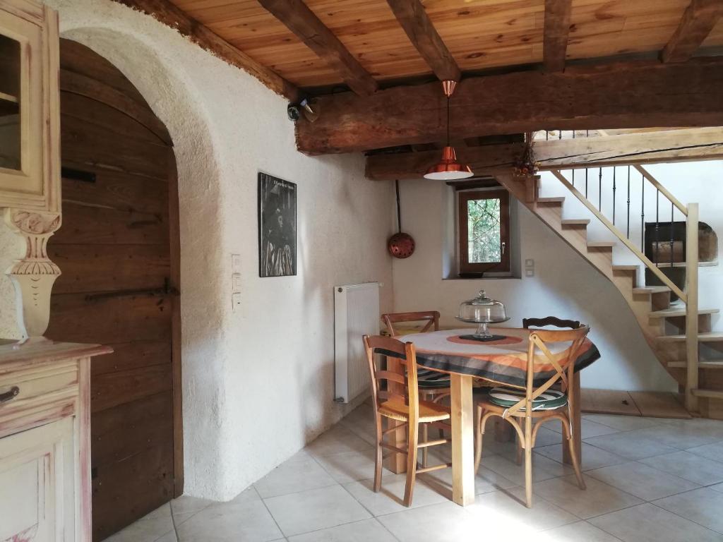 uma sala de jantar com uma mesa e uma escada em Gîte Sainte Croix en Jarez, Le Val des Equins em Sainte-Croix-en-Jarez