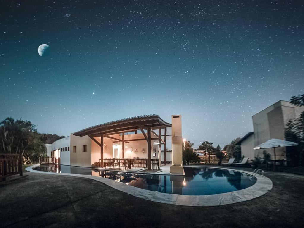 a house with a swimming pool at night with the moon at Bosque da Praia Chalé 5 in Pipa