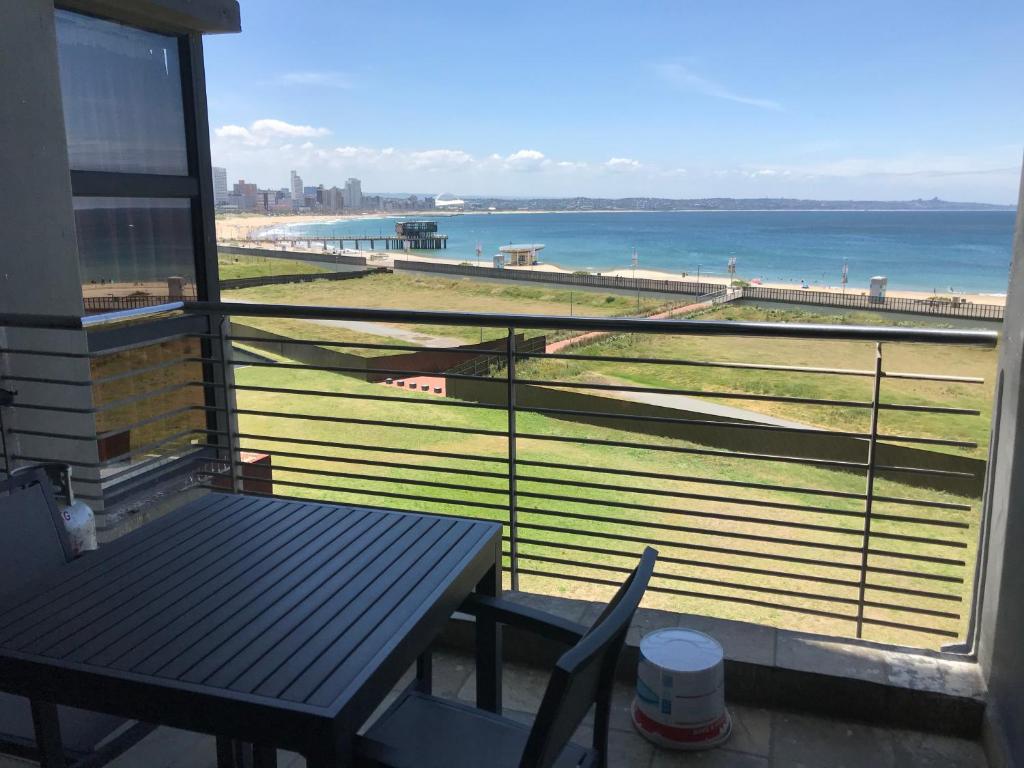 德班的住宿－Durban Point Waterfront, 505 Quayside 40 Canalquay Rd，阳台配有桌子,享有海滩美景