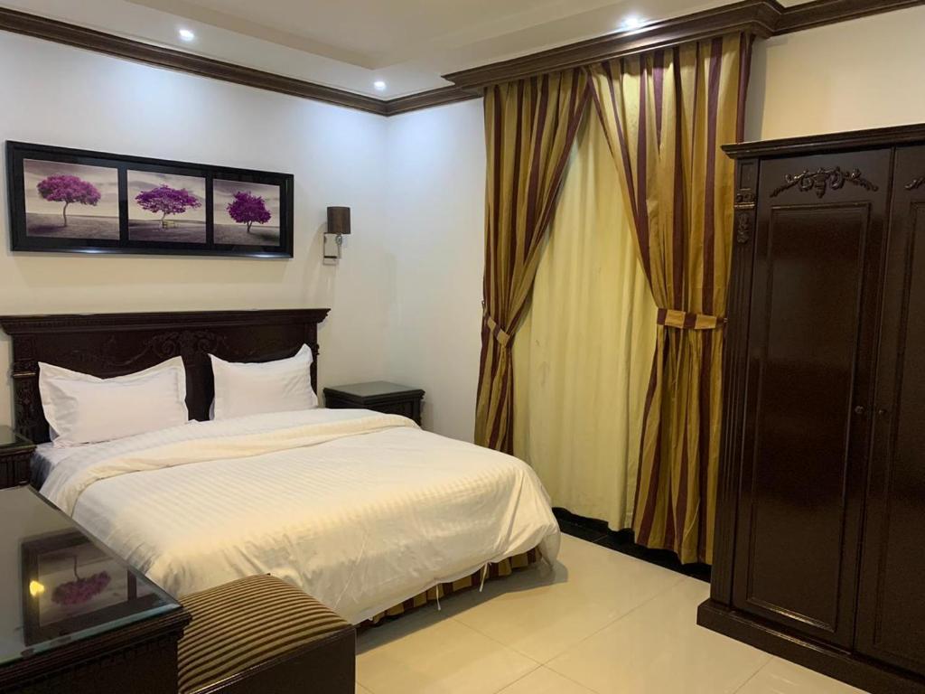 a bedroom with a large bed and a window at Deyala Serviced Apartments 1 in Riyadh