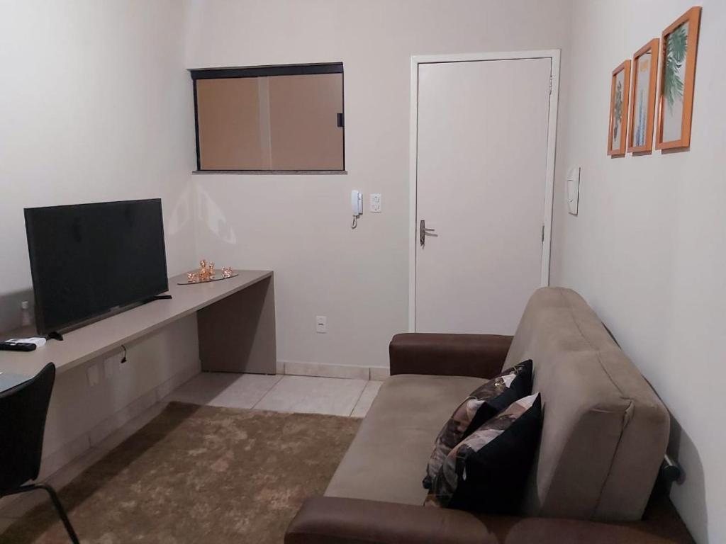 Il comprend un salon doté d'un canapé et d'une télévision à écran plat. dans l'établissement Moradas Pará Satélite 303, à Belém