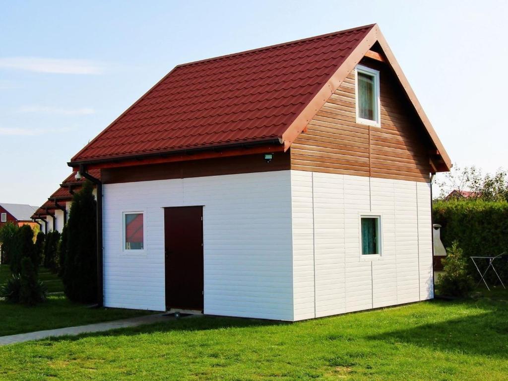 un granero blanco grande con techo rojo en Morska Przygoda en Rewal