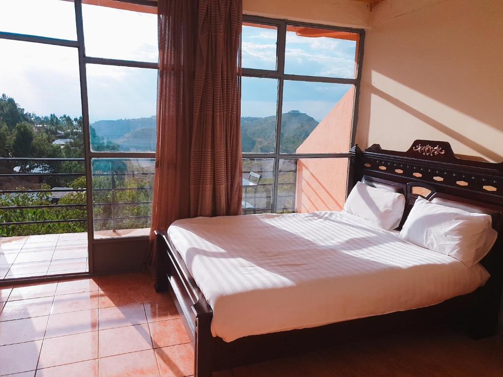 sypialnia z łóżkiem przed oknem w obiekcie Alef Paradise Hotel w mieście Lalibela