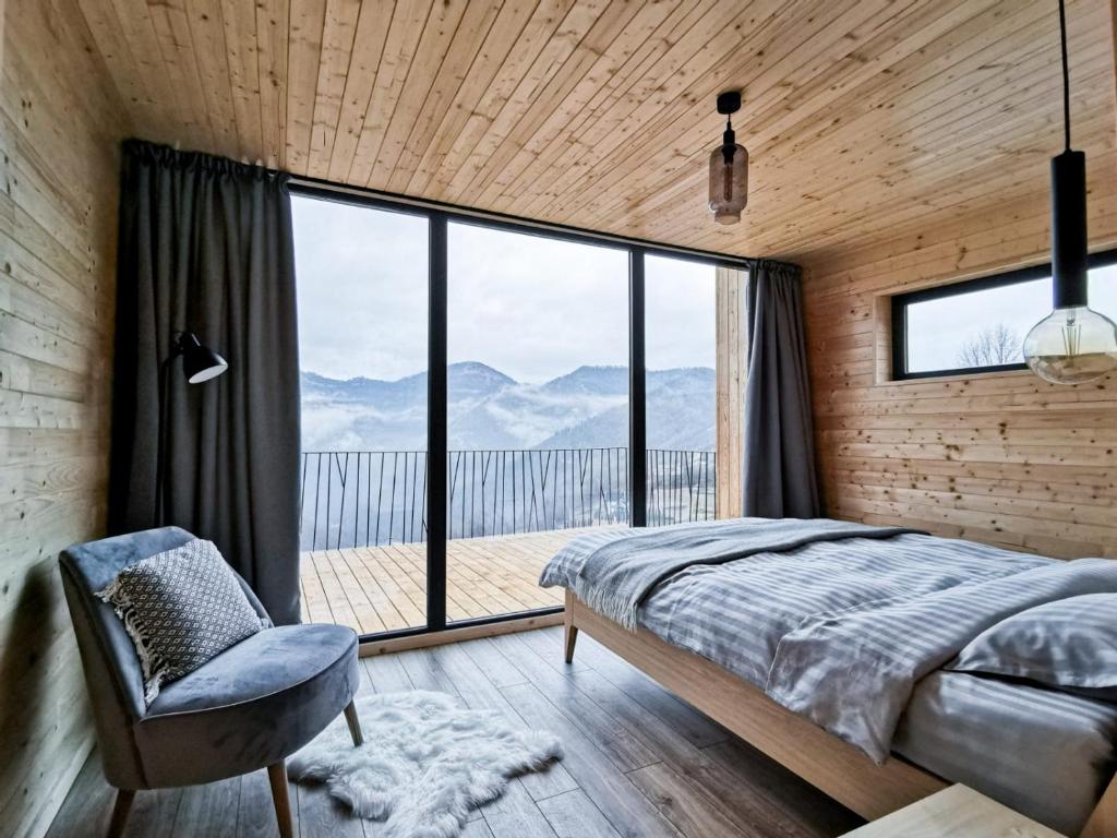 a bedroom with a bed and a large window at Cabana Berg in Someşu Rece