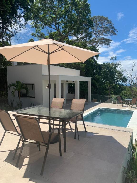 a table with an umbrella next to a swimming pool at Paraíso do Morro dos Ventos in Chapada dos Guimarães