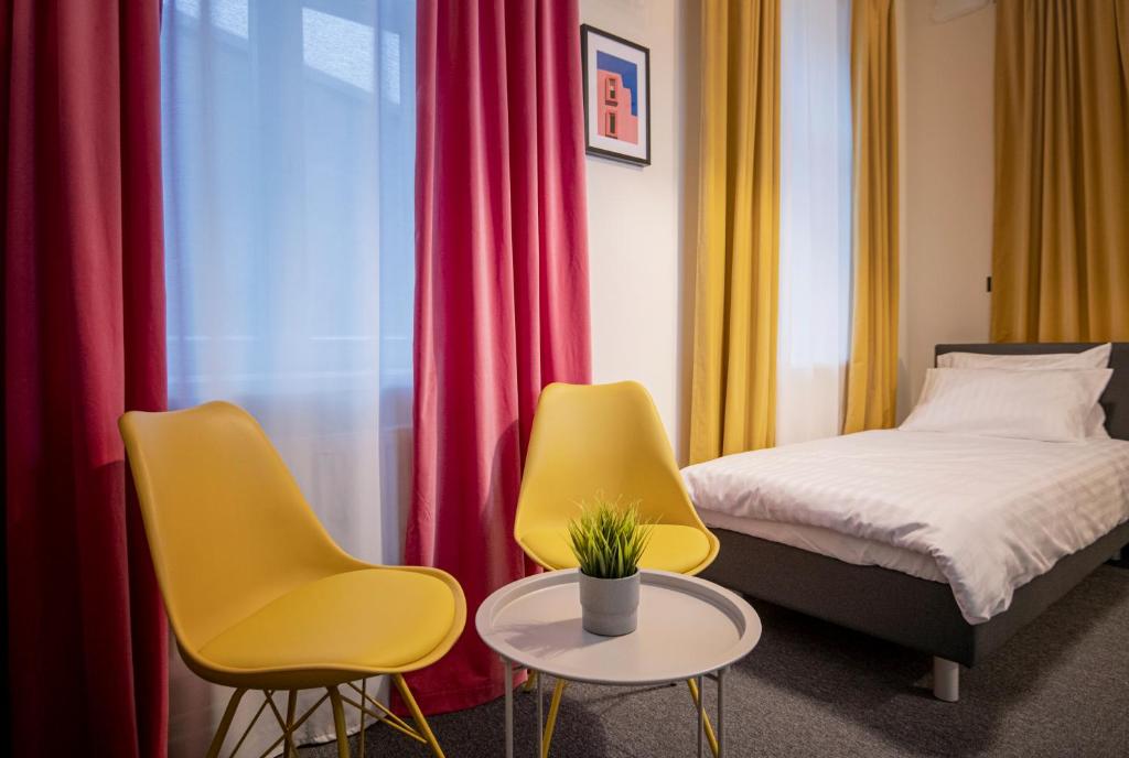 RUMI Hotel with Self Check-In في جيكاببيلس: غرفة نوم بها كرسيين وسرير وطاولة