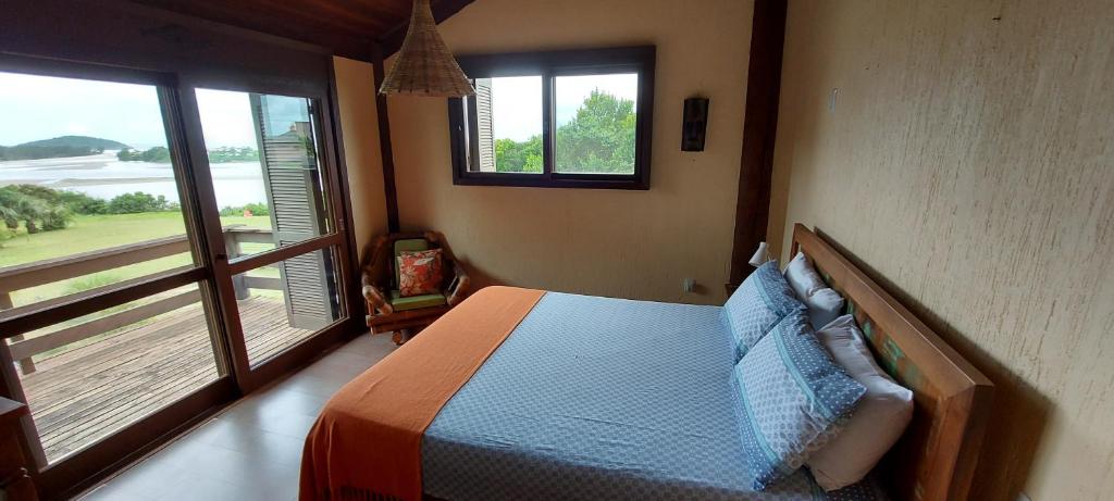 1 dormitorio con 1 cama y balcón en Pousada Águas de Ibiraquera Suite Master, en Imbituba