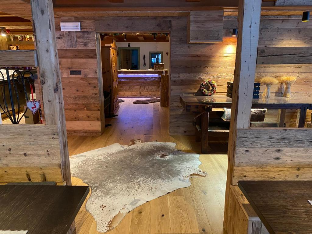a room with wooden walls and a floor with a rug at Hotel Almhof in San Candido