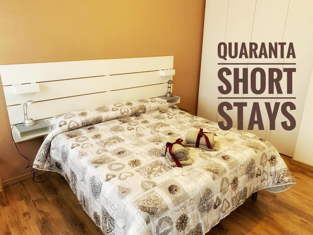 een bed in een kamer met een bord met een quarantaine korte verblijven bij Quaranta Short Stays in Reggio Emilia