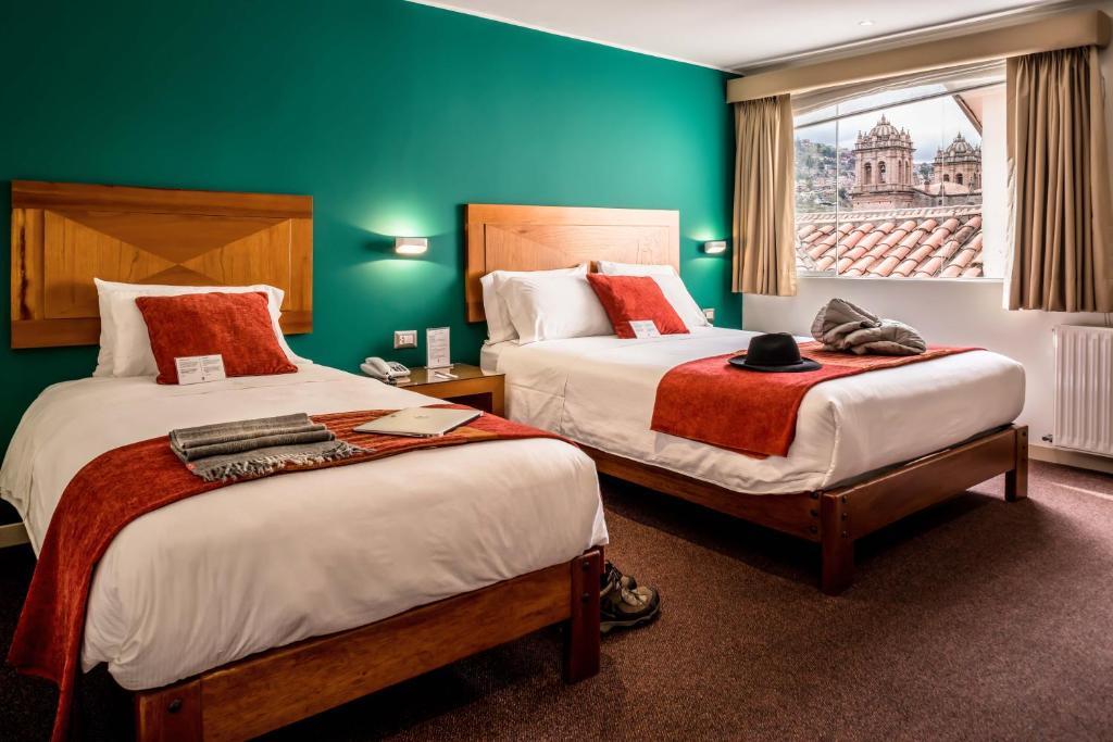 a hotel room with two beds and a window at Maytaq Wasin Boutique Hotel in Cusco