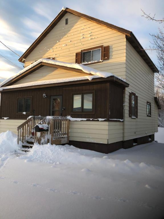 a house with snow on the ground in front of it at The Cary Mine House in Hurley