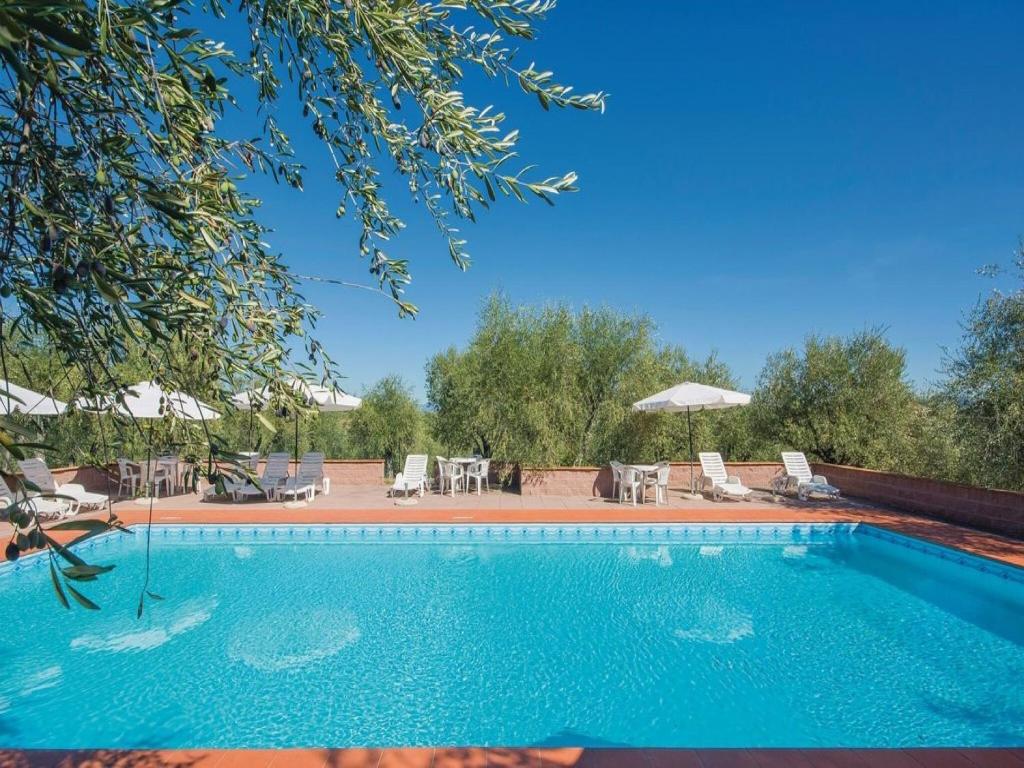 - une grande piscine avec des chaises et un parasol dans l'établissement Belvilla by OYO Casalini 2, à Romola