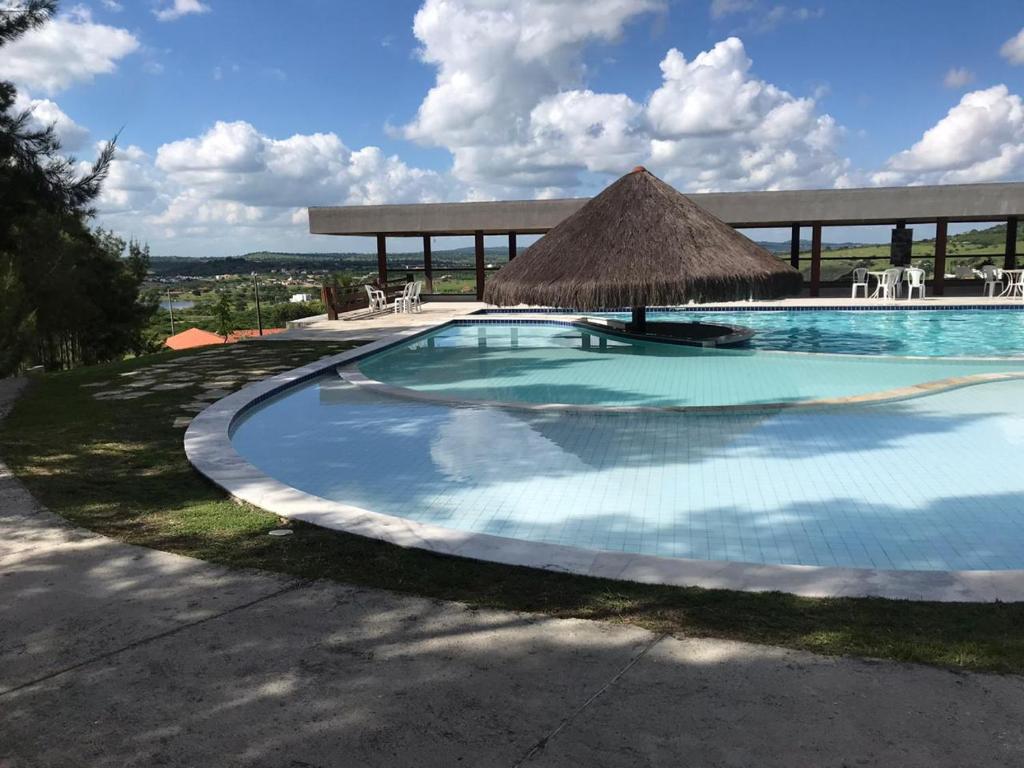 - une grande piscine avec un parasol dans l'établissement Flat Monte Castelo, à Gravatá