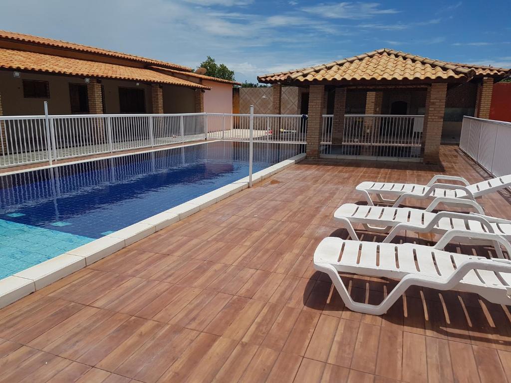 a deck with chairs and a swimming pool at Casa de praia em Beberibe in Beberibe