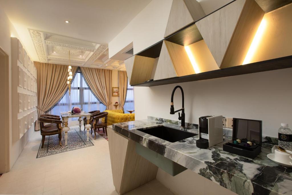 A marble kitchenette beside a formal sitting and dining area.